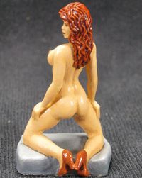 Erotic figurine of a naked woman in red shoes with high heels, kneeling.